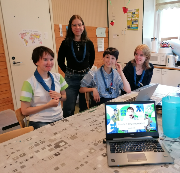 Neljä partionuorta pöydän äärellä.